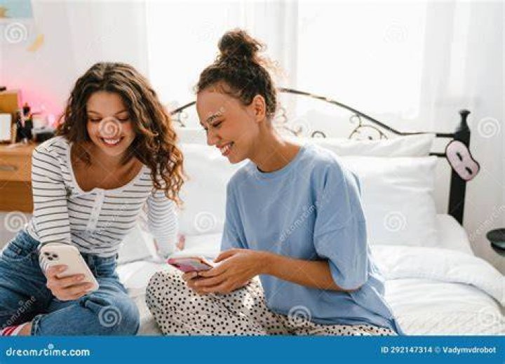 Young girls using phone, sitting legs crossed Stock Vector Image & Art